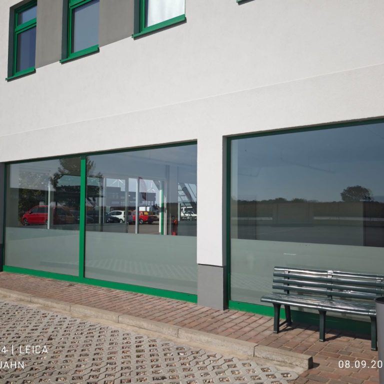 Fensterreinigung Moderne Fassade eines Gebäudes mit großen Fenstern und einem wartenden Bank.